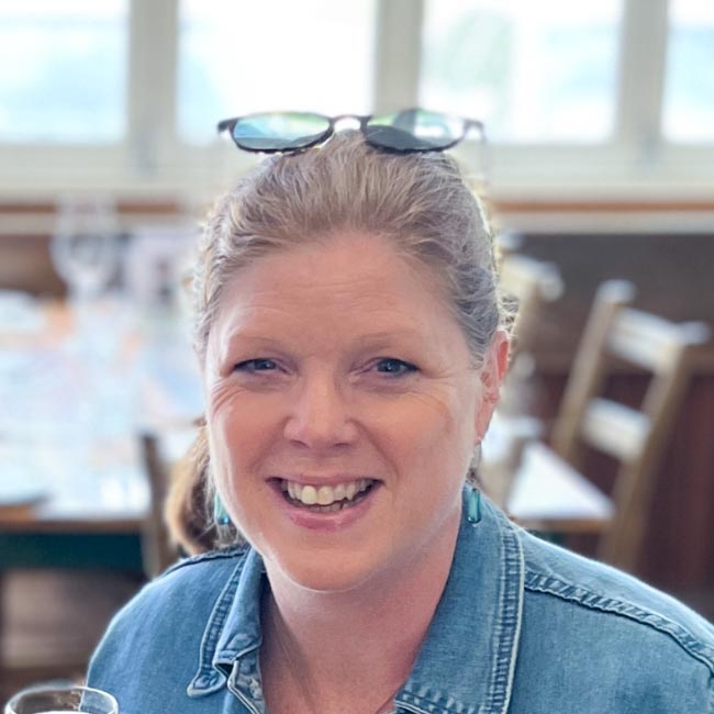 Doggy Wine Tour Guide – Helen A woman, Helen, your tour guide, sitting on some stone steps